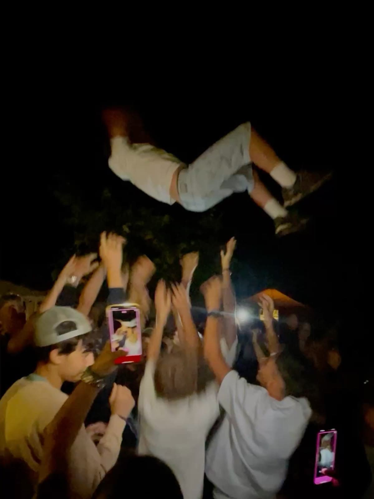 Mission proof: a crowd lifting a friend into the air while everyone films