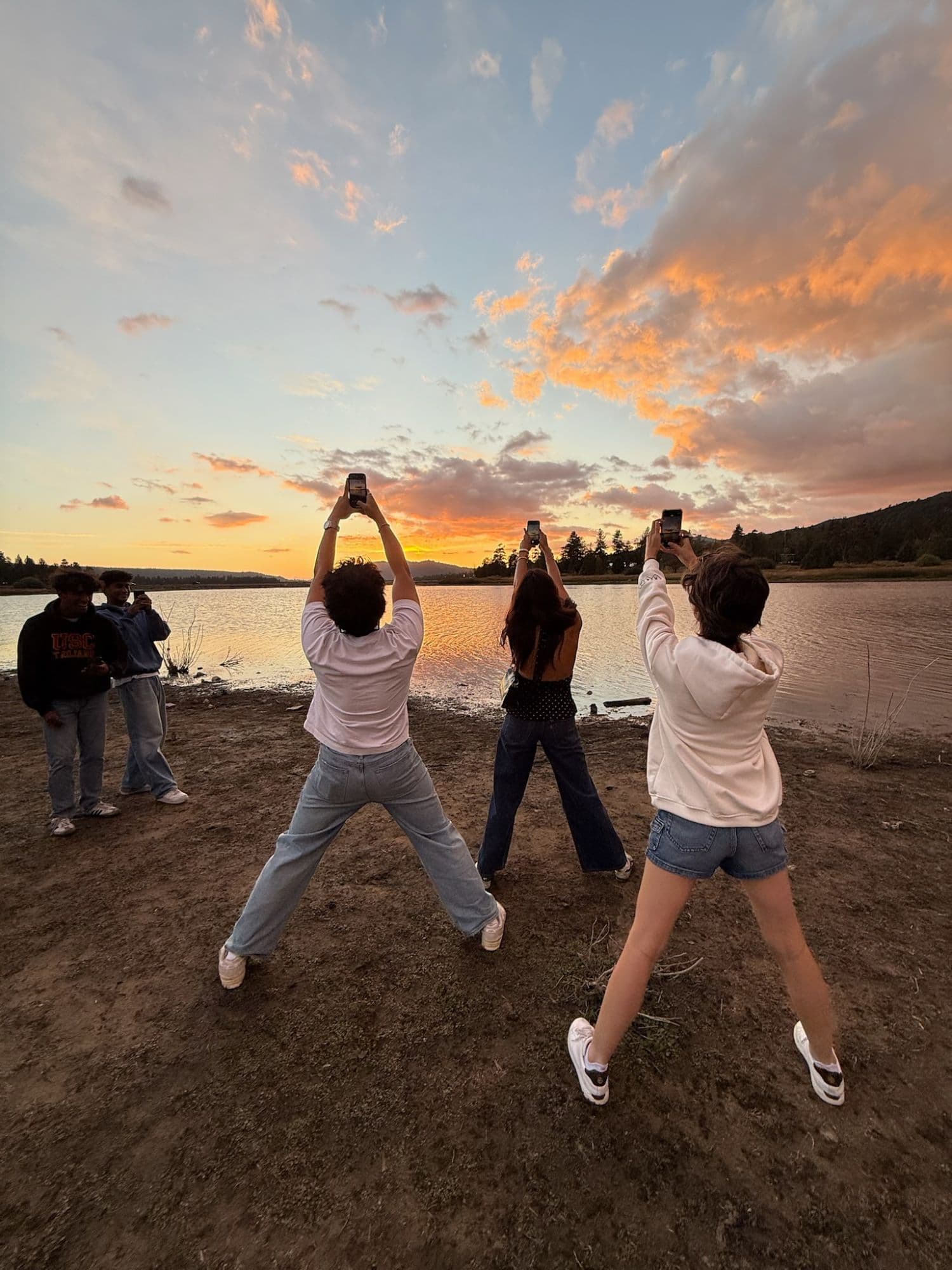 Recap cover photo: friends filming the sunset over a lake